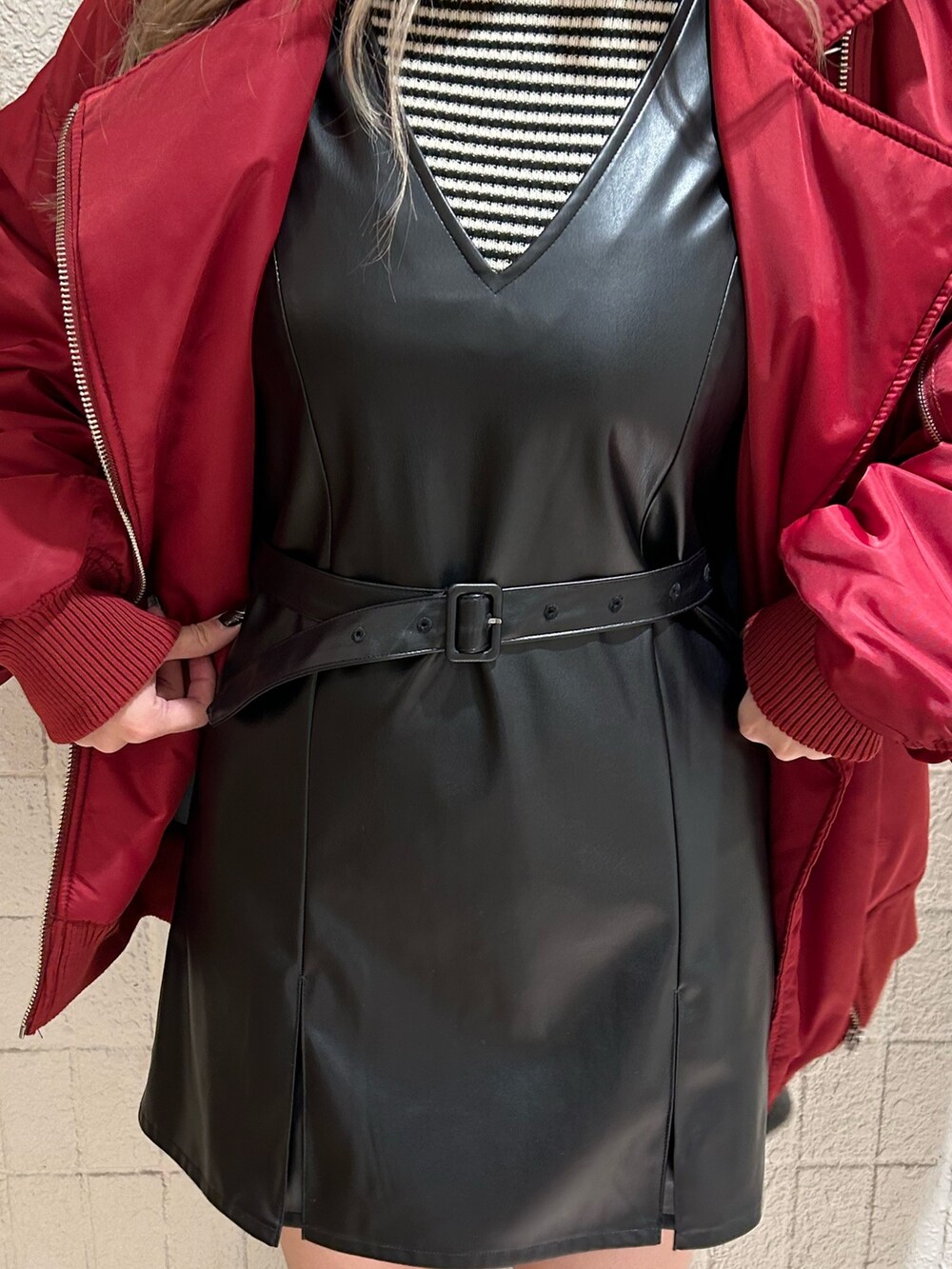 レッド系のMA-1、ブラック系のブーツ、ブラック系のジャンパースカートを着用したレディースの冬コーディネートの7枚目の写真