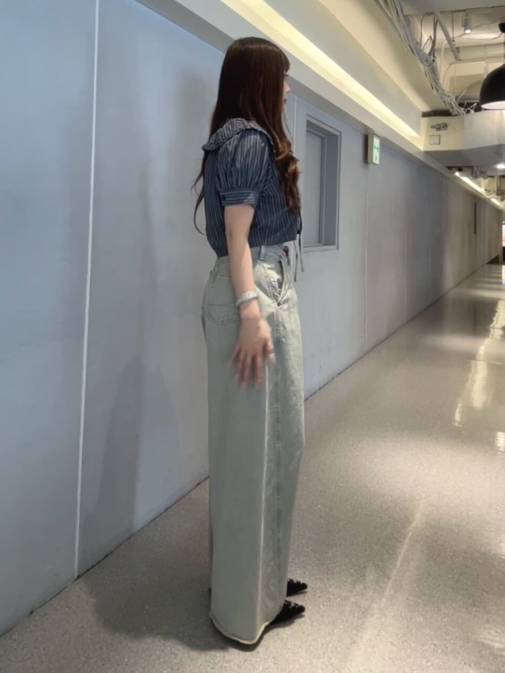 ブラック系のパンプス、ブラック系のシャツ/ブラウス、ブルー系のデニムパンツを着用したレディースの春コーディネートの2枚目の写真