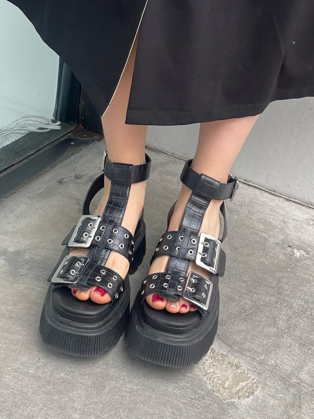 ブラック系のワンピース、ブラック系のサンダル、シルバー系のピアス（両耳用）を着用したレディースの春コーディネートの6枚目の写真