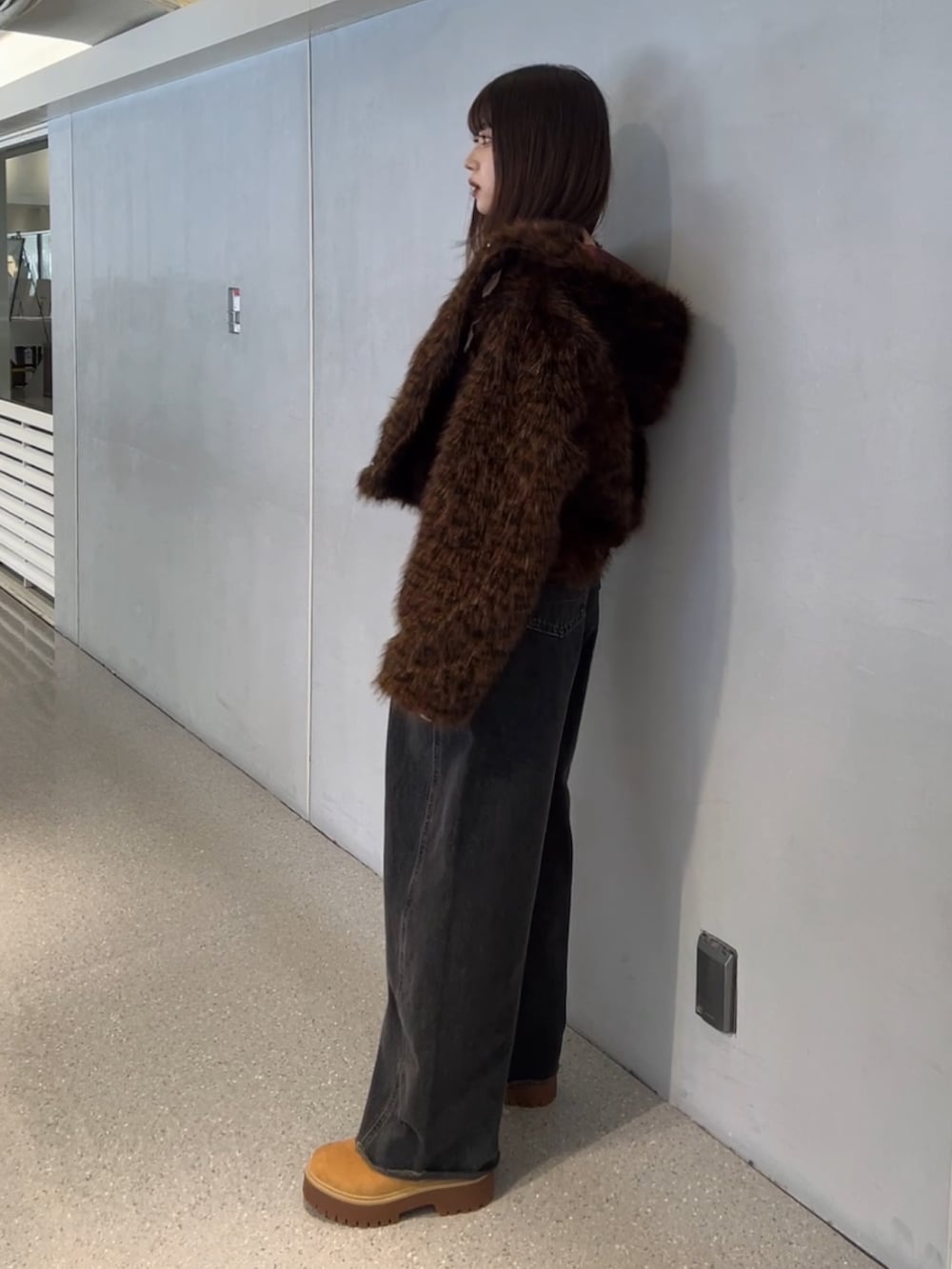 ブラウン系のブルゾン、ブラック系のデニムパンツを着用したレディースの秋コーディネートの3枚目の写真