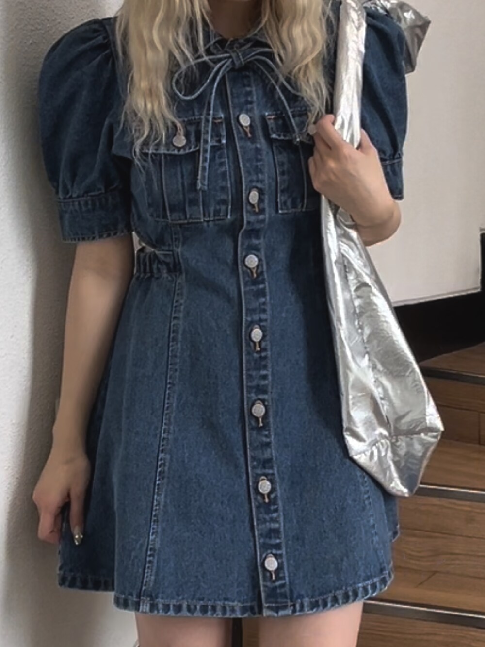 ブルー系のワンピース、シルバー系のトートバッグを着用したレディースの春コーディネートの6枚目の写真