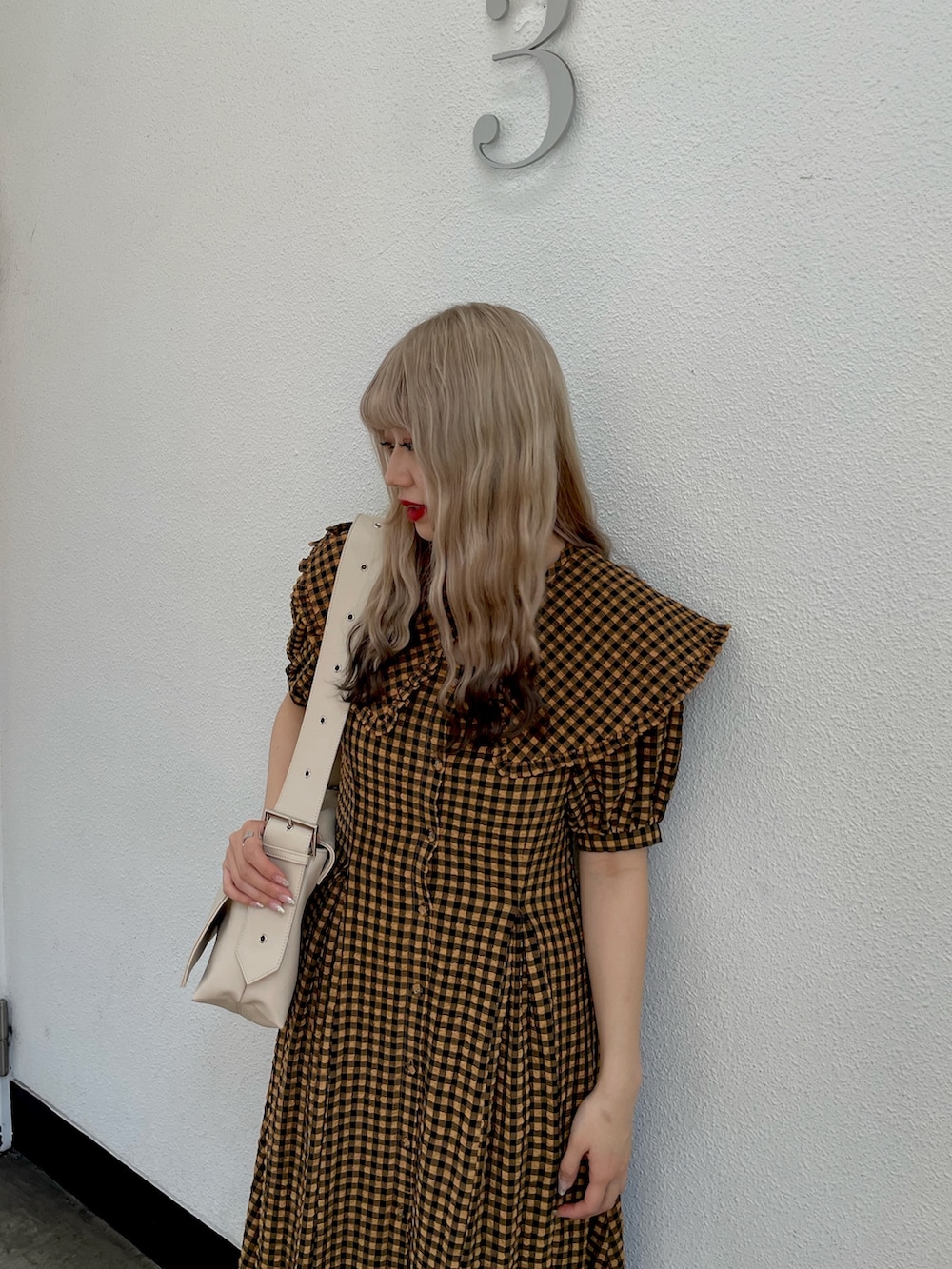 ブラウン系のワンピース、ブラック系のその他シューズ、ホワイト系のメッセンジャーバッグを着用したレディースの春コーディネートの3枚目の写真