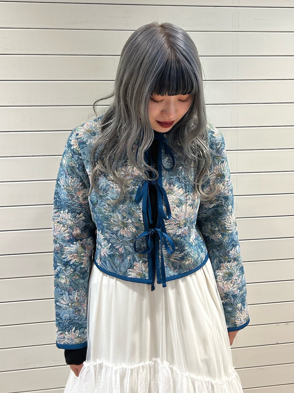 ブラック系のニット/セーター、ブルー系のノーカラージャケット、ホワイト系のスカートを着用したレディースの冬コーディネートの4枚目の写真