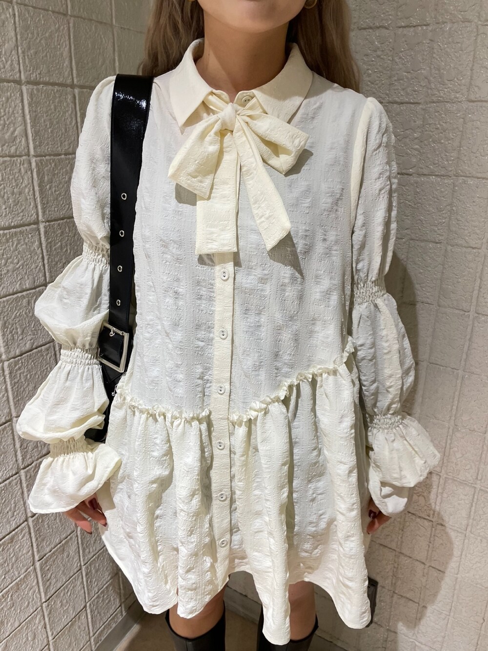 ブラック系のデニムパンツ、ホワイト系のシャツ/ブラウス、ブラック系のブーツを着用したレディースの冬コーディネートの5枚目の写真