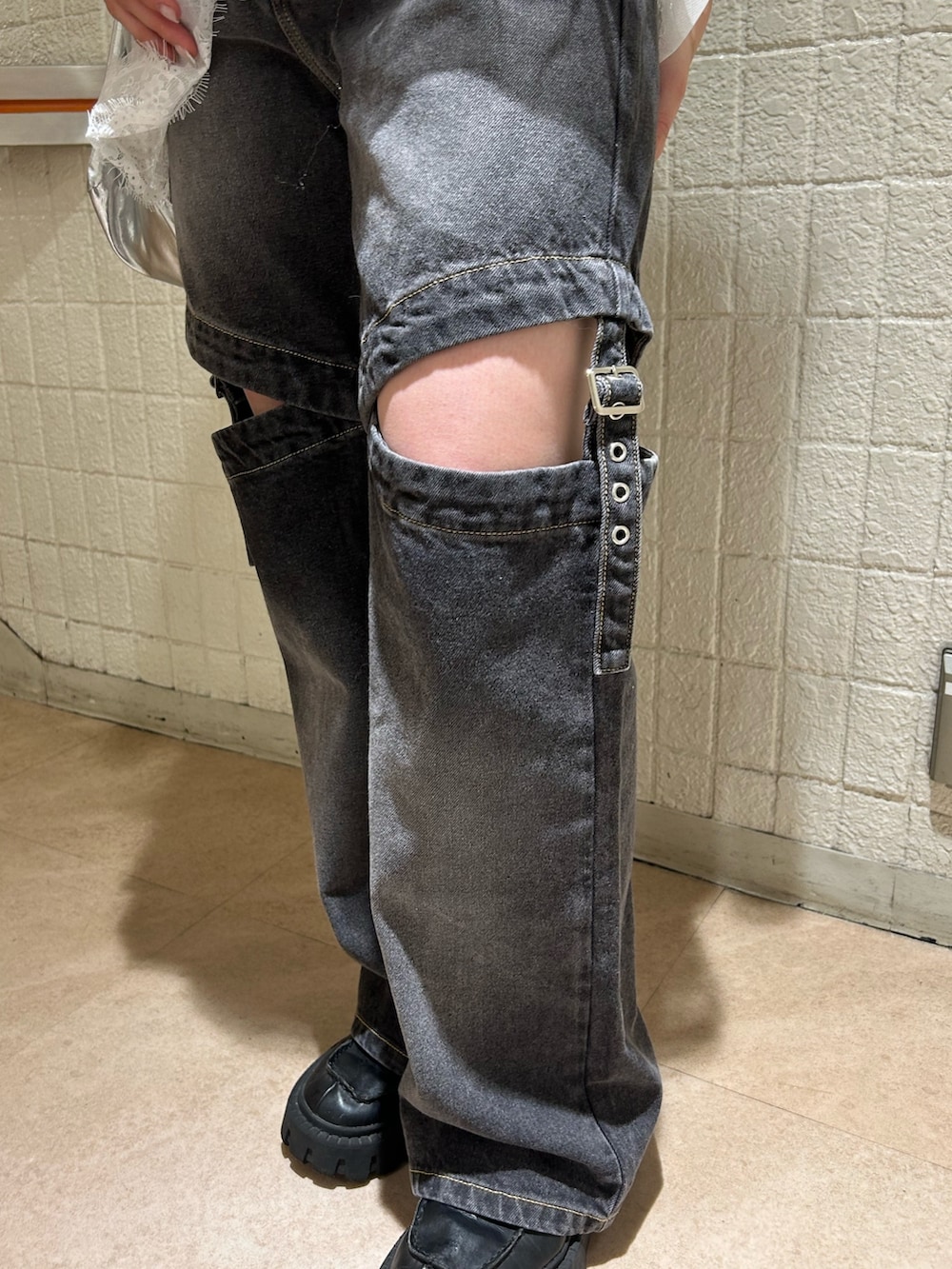 ホワイト系のTシャツ/カットソー、ブラック系のデニムパンツ、シルバー系のトートバッグを着用したレディースの春コーディネートの7枚目の写真