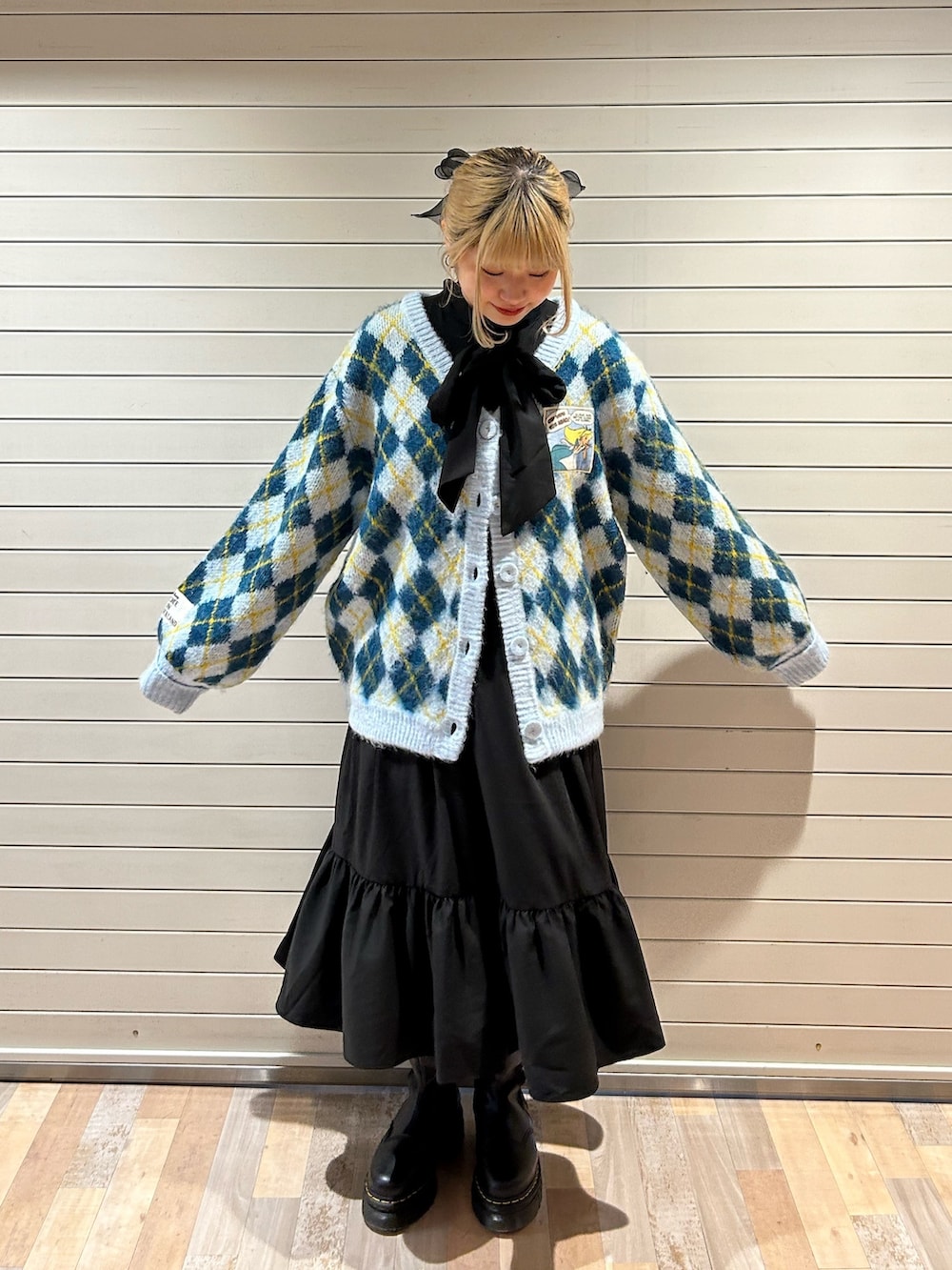 ブラック系のブーツ、ブルー系のカーディガン/ボレロ、ブラック系のワンピースを着用したレディースの秋コーディネートの3枚目の写真