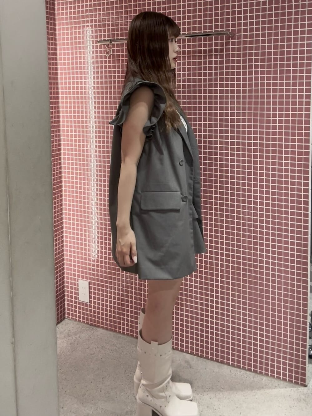 グレー系のワンピース、ホワイト系のアンサンブル、ホワイト系のブーツを着用したレディースの夏コーディネートの3枚目の写真