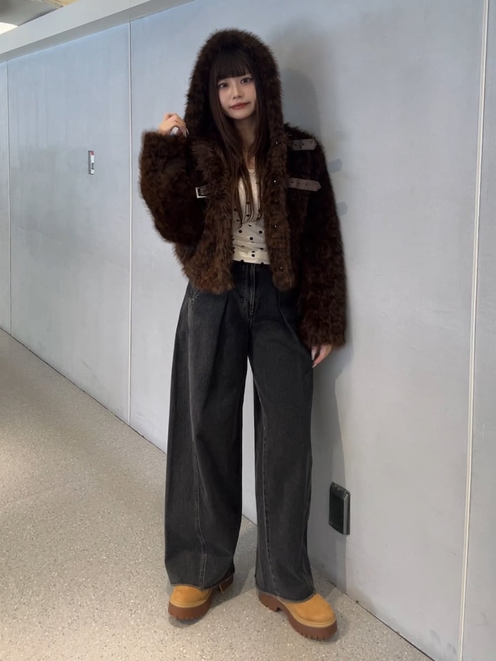 ブラウン系のブルゾン、ブラック系のデニムパンツを着用したレディースの秋コーディネートの2枚目の写真