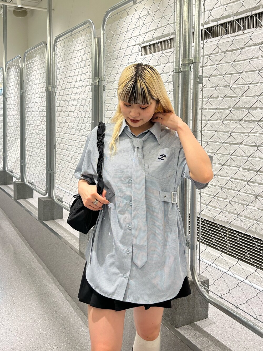 ブルー系のシャツ/ブラウス、ブラック系のスカート、ブラック系のショルダーバッグを着用したレディースの夏コーディネートの6枚目の写真