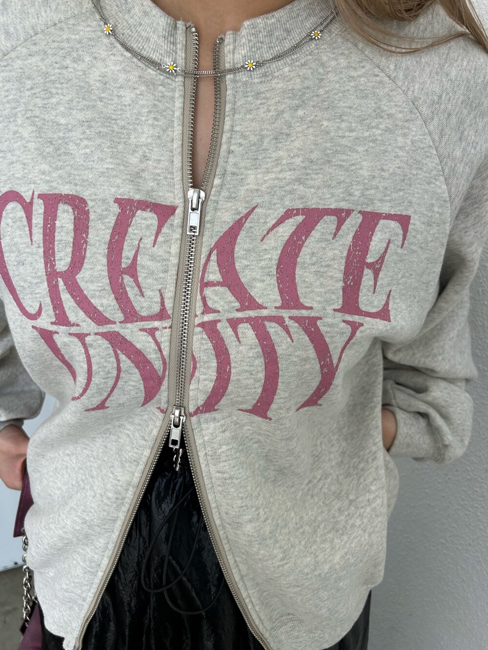 グレー系のスウェット、ブラック系のスカート、パープル系のハンドバッグを着用したレディースの秋コーディネートの6枚目の写真