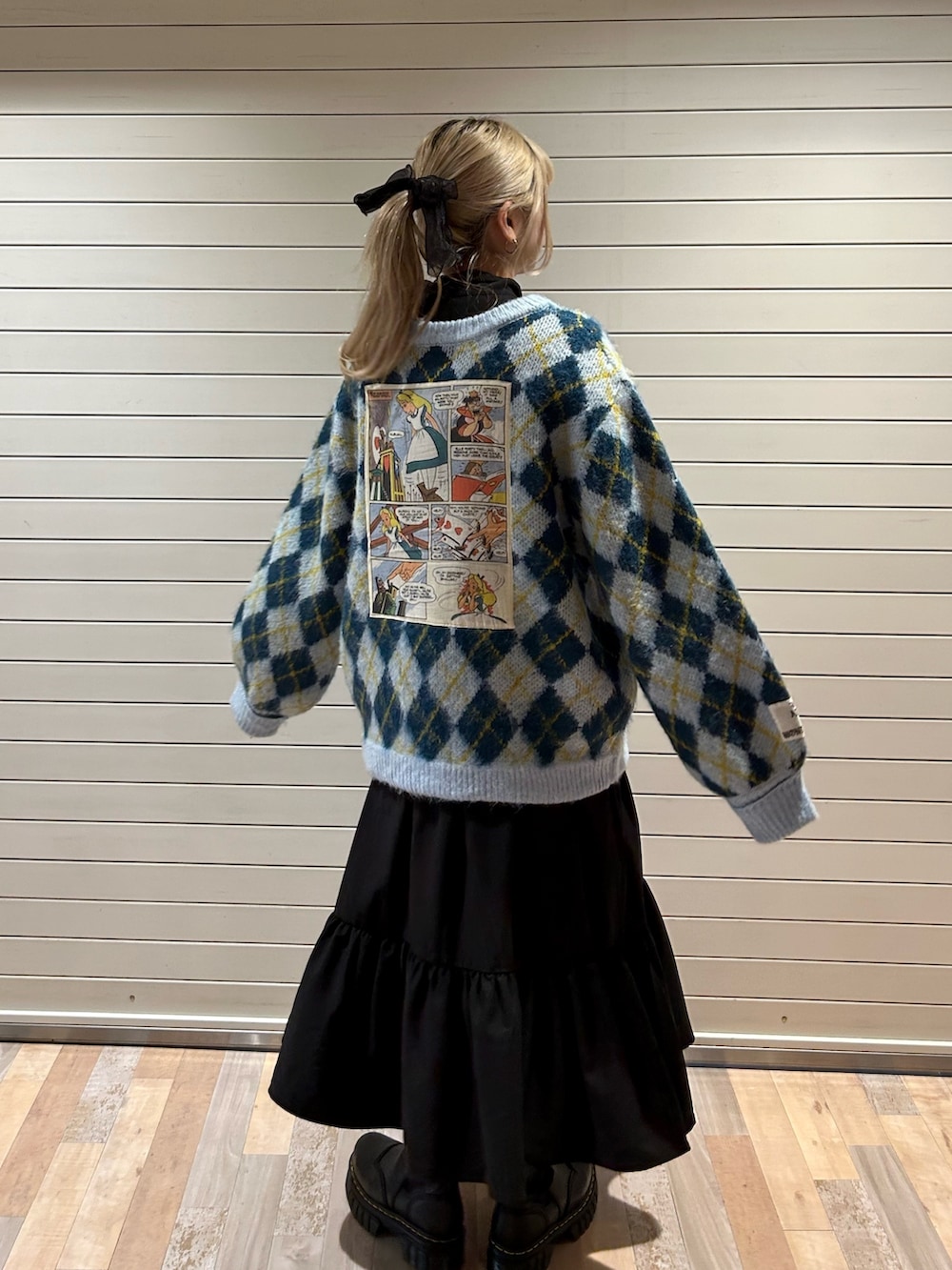 ブラック系のブーツ、ブルー系のカーディガン/ボレロ、ブラック系のワンピースを着用したレディースの秋コーディネートの4枚目の写真