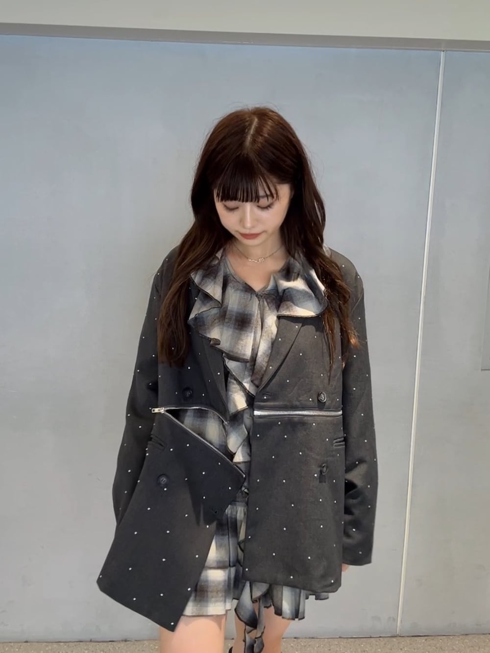 グレー系のテーラードジャケット、ブラウン系のワンピース、ブラック系のブーツを着用したレディースの秋コーディネートの5枚目の写真