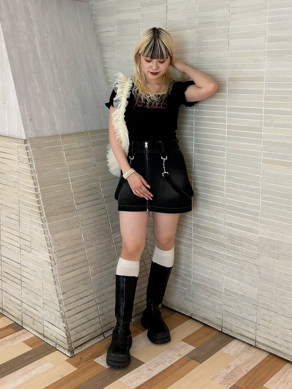 ブラック系のTシャツ/カットソー、ホワイト系のショルダーバッグ、ブラック系のデニムスカートを着用したレディースの夏コーディネートの2枚目の写真