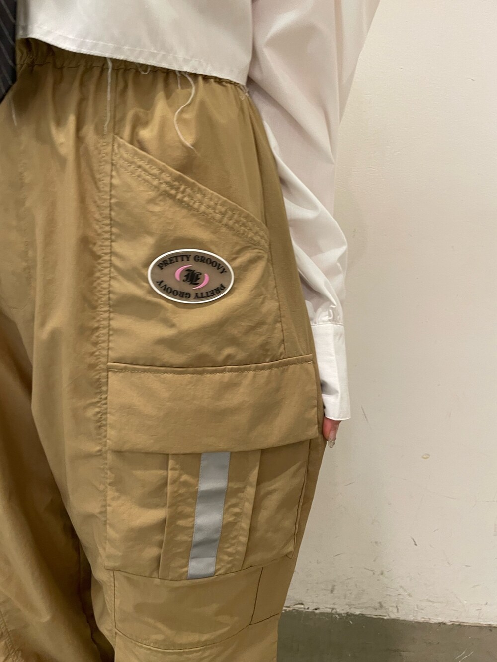 ホワイト系のシャツ/ブラウス、ベージュ系のカーゴパンツ、ブラック系のその他シューズを着用したレディースの夏コーディネートの7枚目の写真
