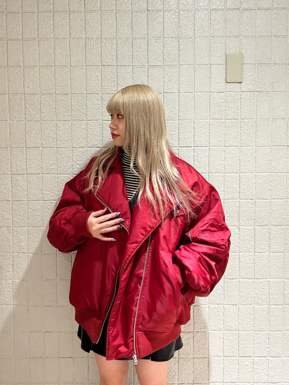 レッド系のMA-1、ブラック系のブーツ、ブラック系のジャンパースカートを着用したレディースの冬コーディネートの4枚目の写真