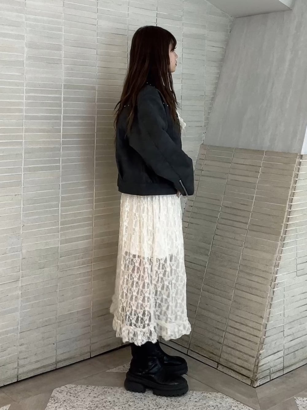 ホワイト系のワンピース、ブラック系のブルゾンを着用したレディースの冬コーディネートの2枚目の写真