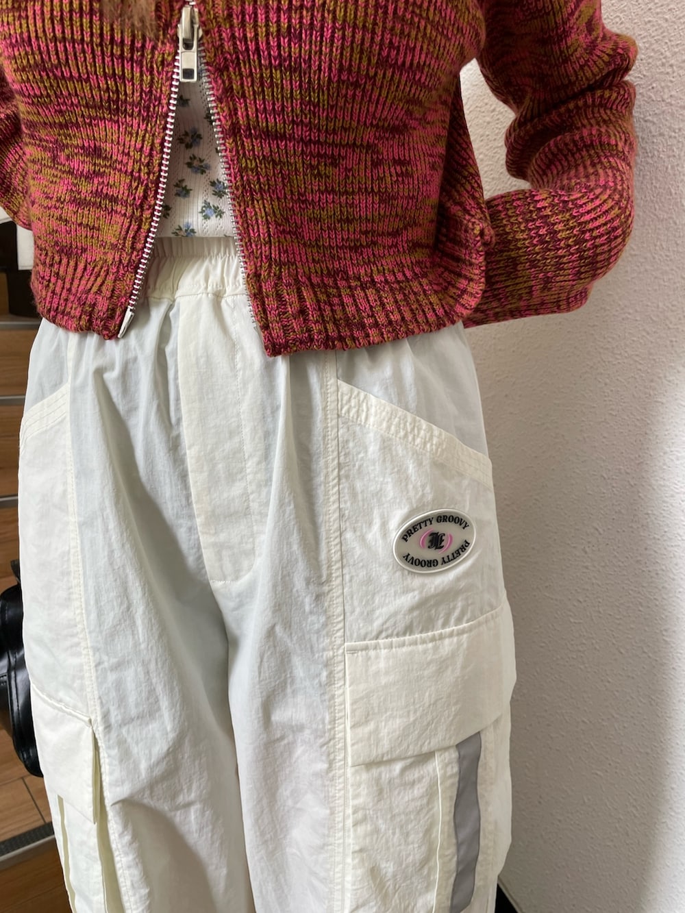 ピンク系のカーディガン/ボレロ、ブラック系のその他シューズ、ホワイト系のカーゴパンツを着用したレディースの夏コーディネートの5枚目の写真