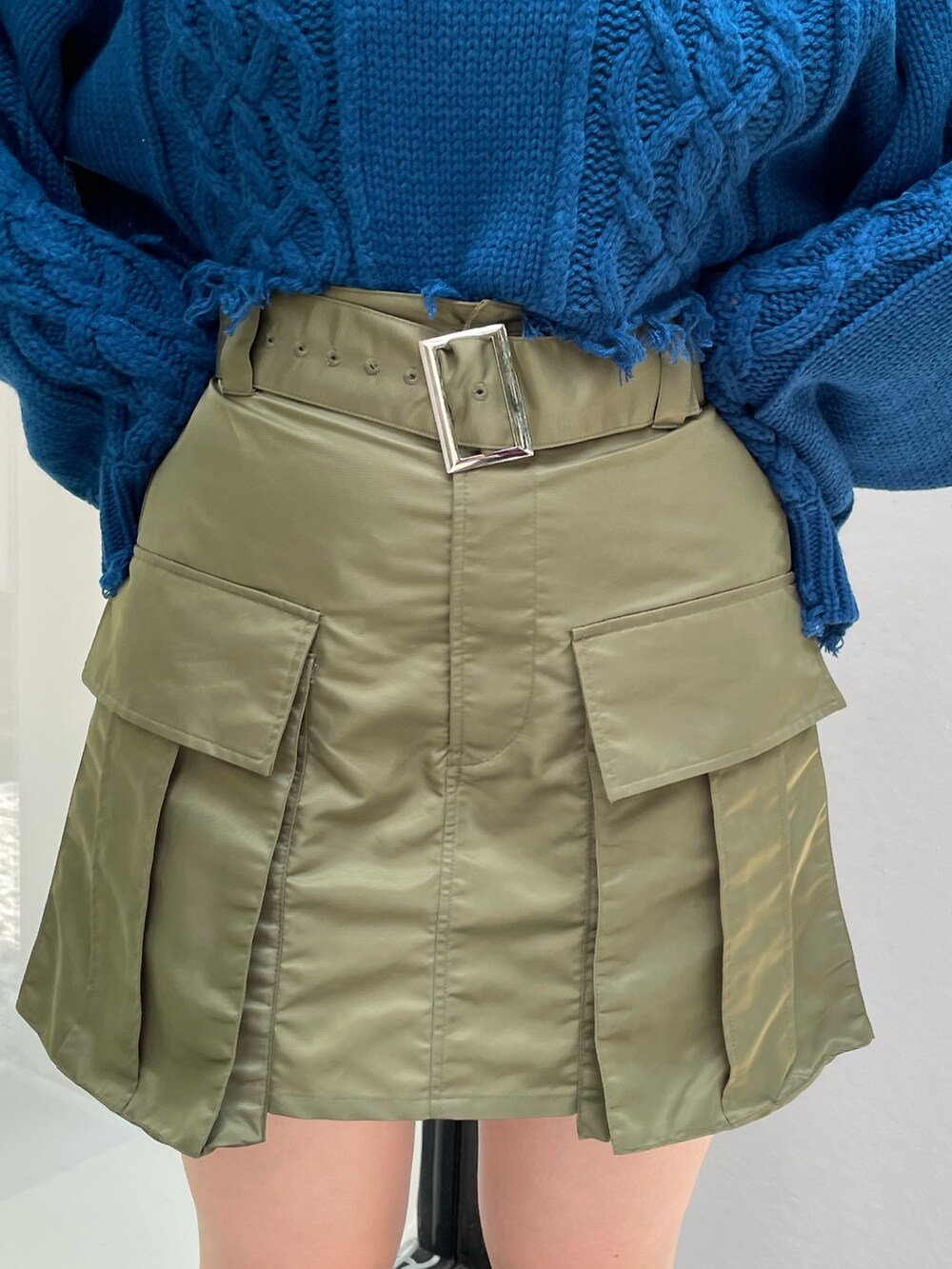 ブルー系のニット/セーター、グリーン系のその他パンツ、ブラック系のブーツを着用したレディースの秋コーディネートの7枚目の写真