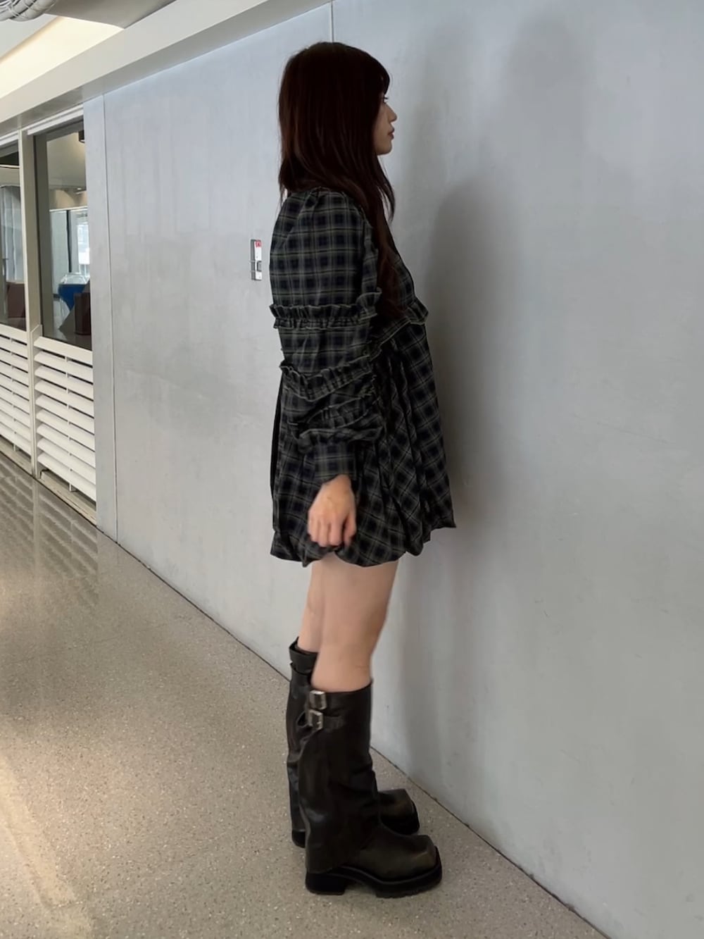 グリーン系のワンピース、ブラック系のブーツを着用したレディースの秋コーディネートの3枚目の写真