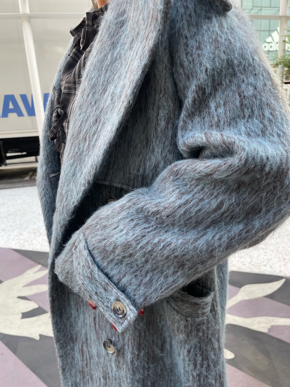 ブルー系のチェスターコート、ブラック系のワンピース、ブラック系のその他シューズを着用したレディースの冬コーディネートの6枚目の写真