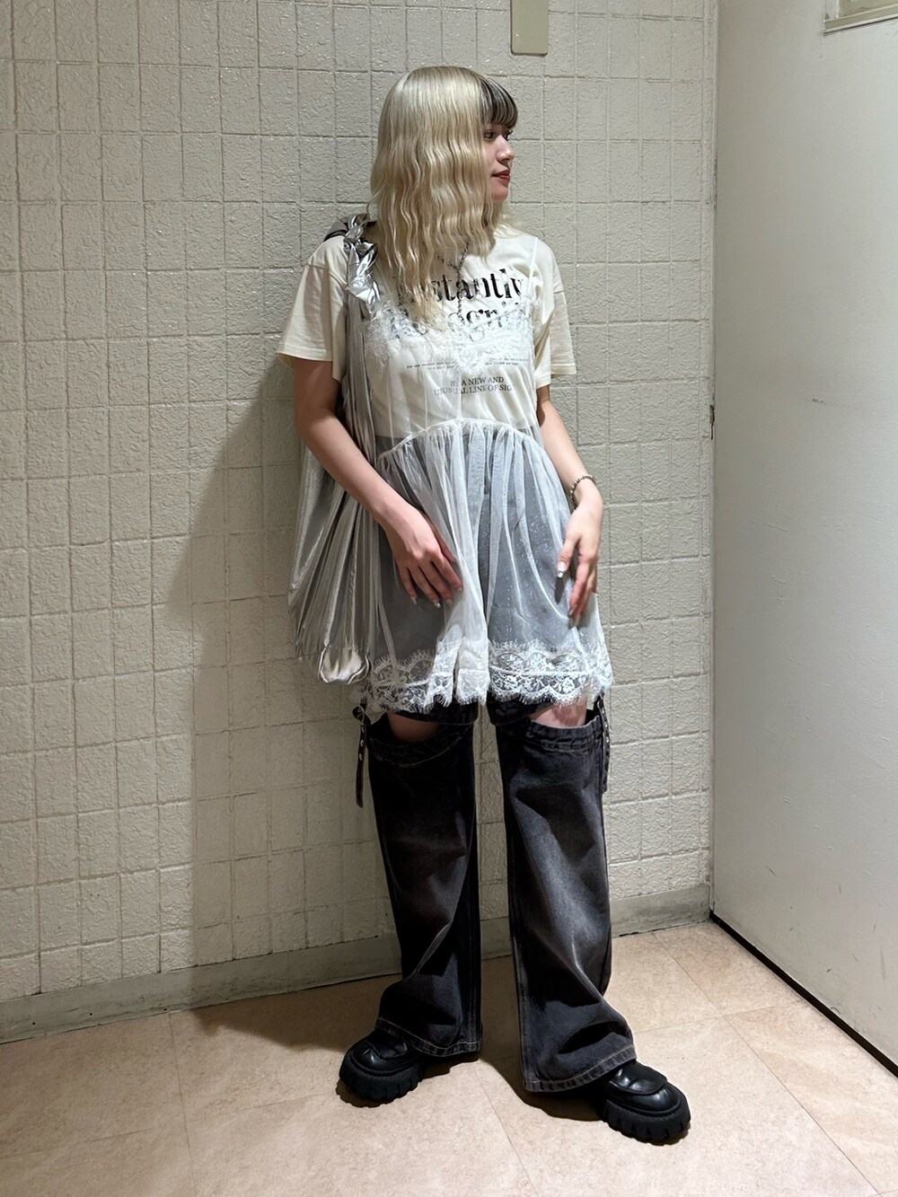 ホワイト系のTシャツ/カットソー、ブラック系のデニムパンツ、シルバー系のトートバッグを着用したレディースの春コーディネートの2枚目の写真