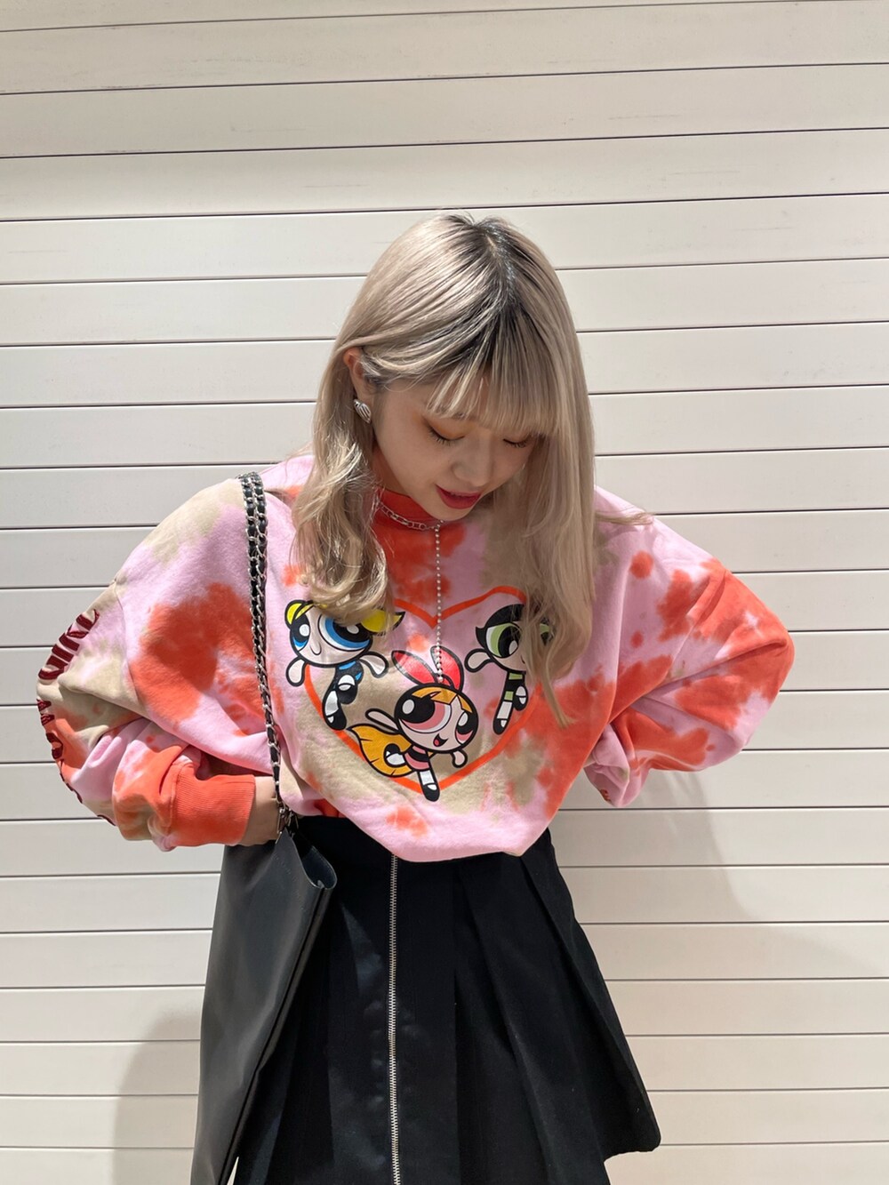 ピンク系のスウェット、ブラック系のその他パンツ、ブラック系のトートバッグを着用したレディースの冬コーディネートの2枚目の写真