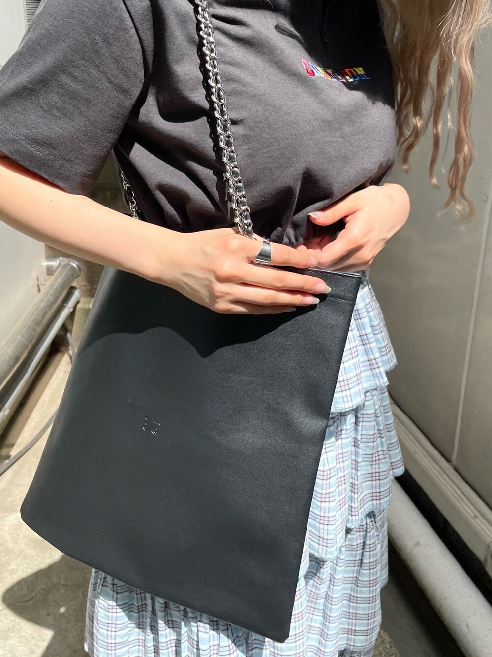 ブラック系のTシャツ/カットソー、ブラック系のトートバッグ、ブルー系のスカートを着用したレディースの春コーディネートの6枚目の写真