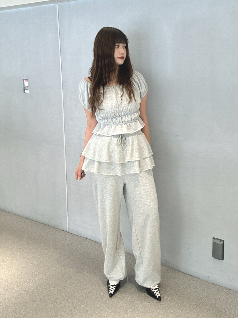 グレー系のTシャツ/カットソー、グレー系のスウェットパンツ、ブラック系のパンプスを着用したレディースの夏コーディネートの2枚目の写真