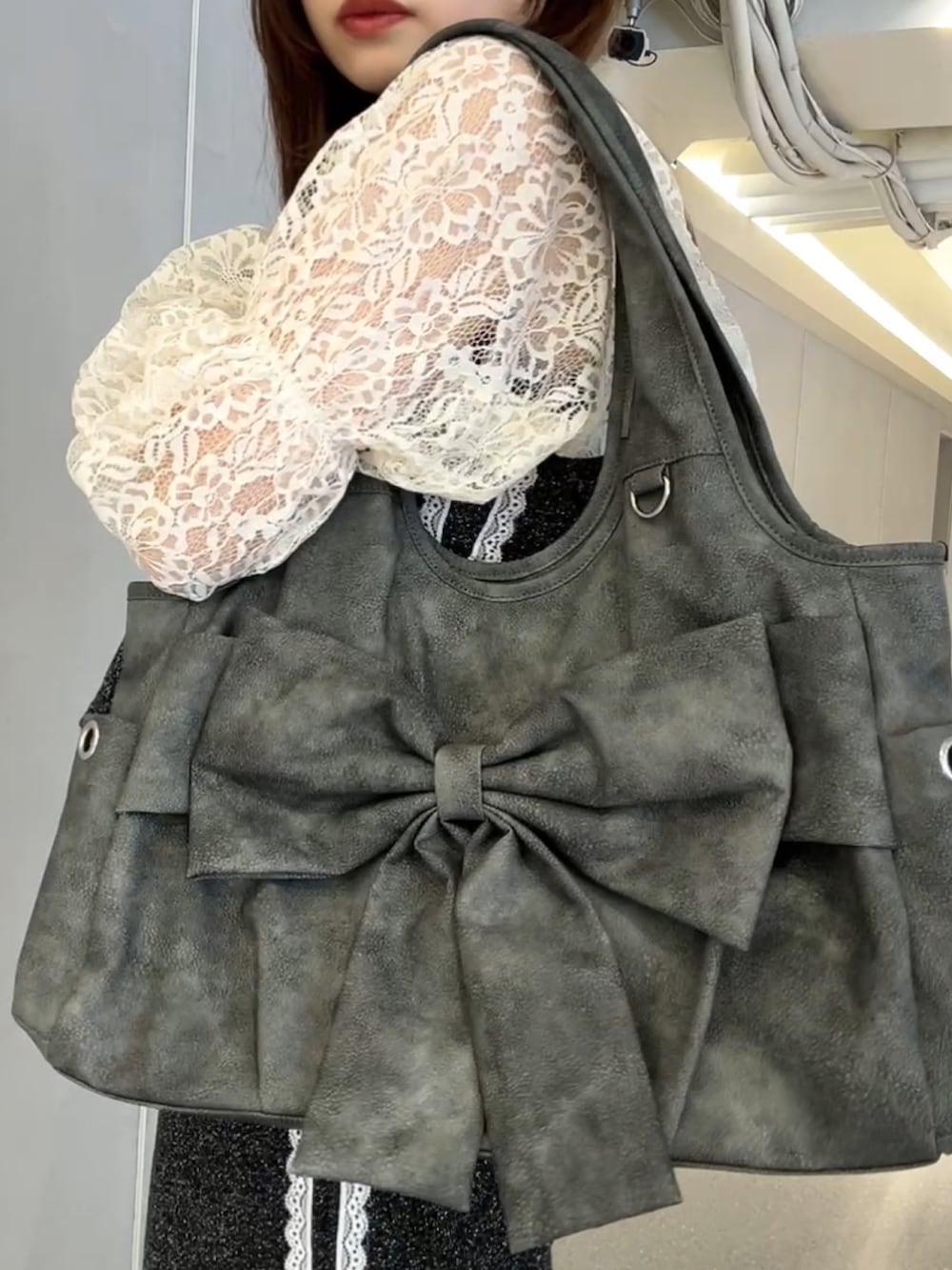 ホワイト系のカーディガン/ボレロ、グレー系のトートバッグ、ブラック系のキャミソールを着用したレディースの春コーディネートの4枚目の写真