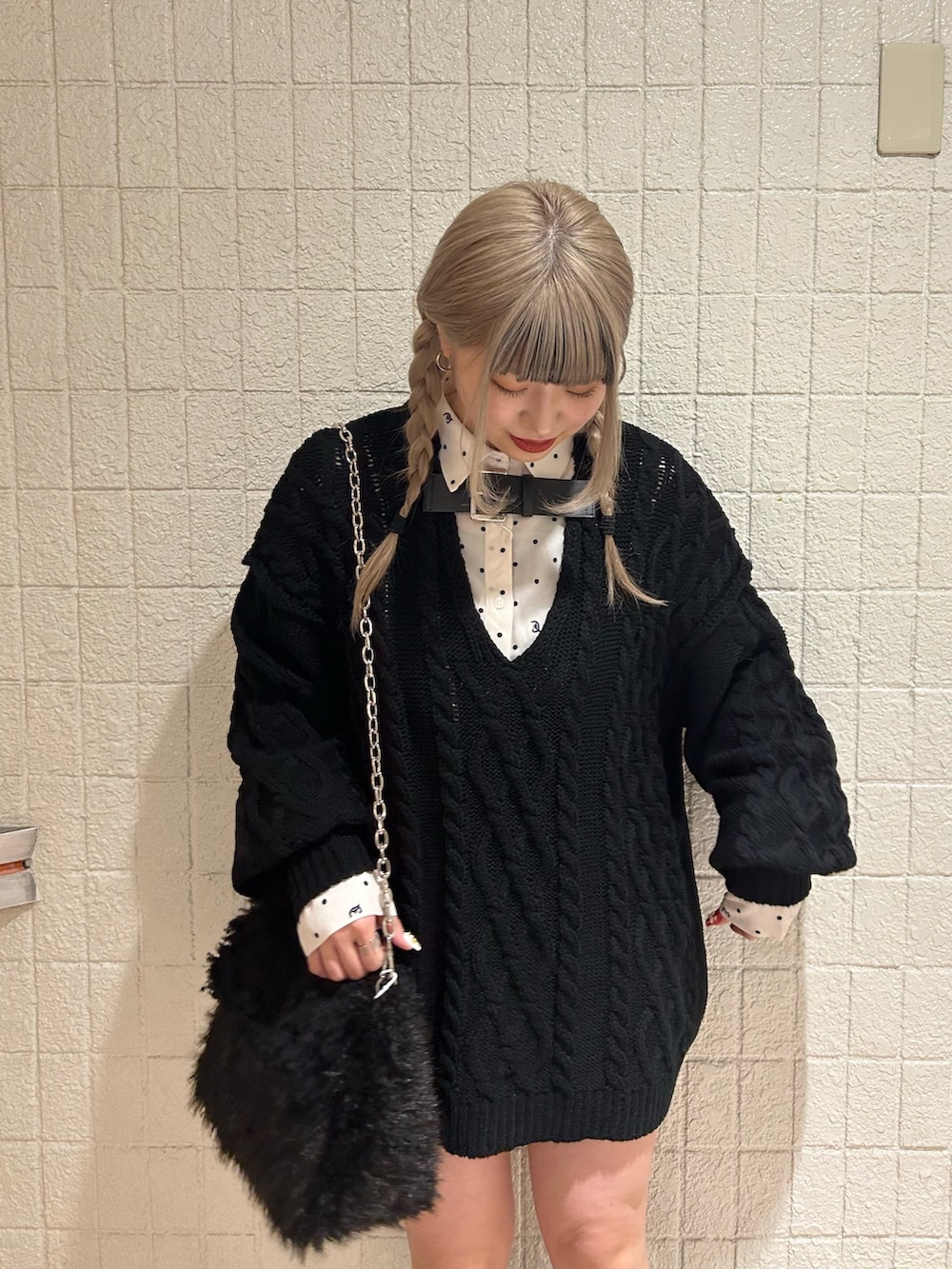 ブラック系のニット/セーター、ブラック系のブーツ、ホワイト系のシャツ/ブラウスを着用したレディースの冬コーディネートの5枚目の写真