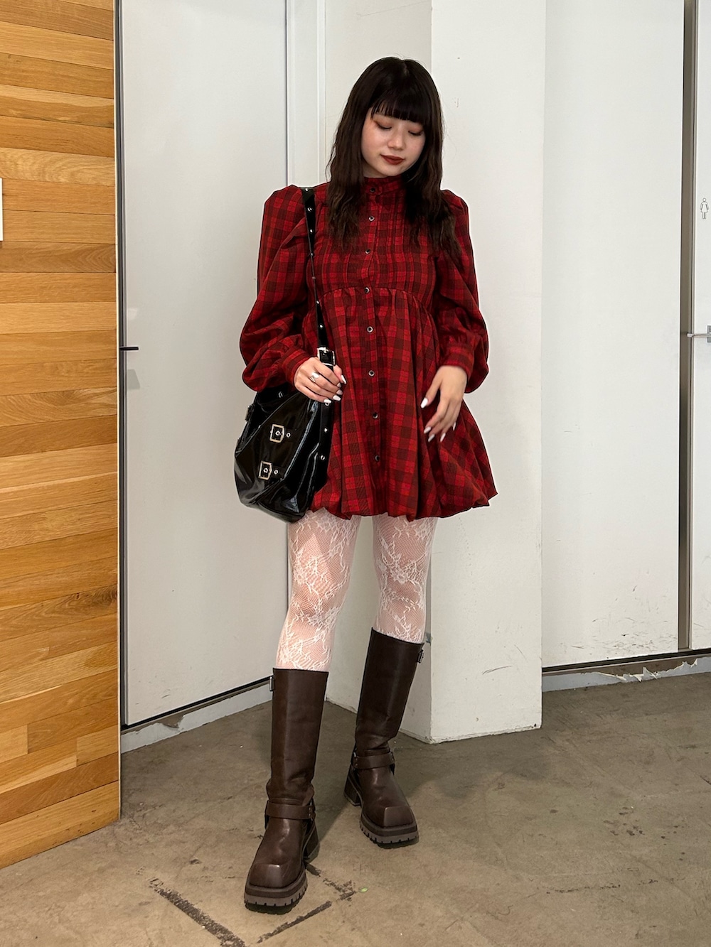 レッド系のワンピース、ブラウン系のブーツ、ブラック系のショルダーバッグを着用したレディースの夏コーディネートの2枚目の写真