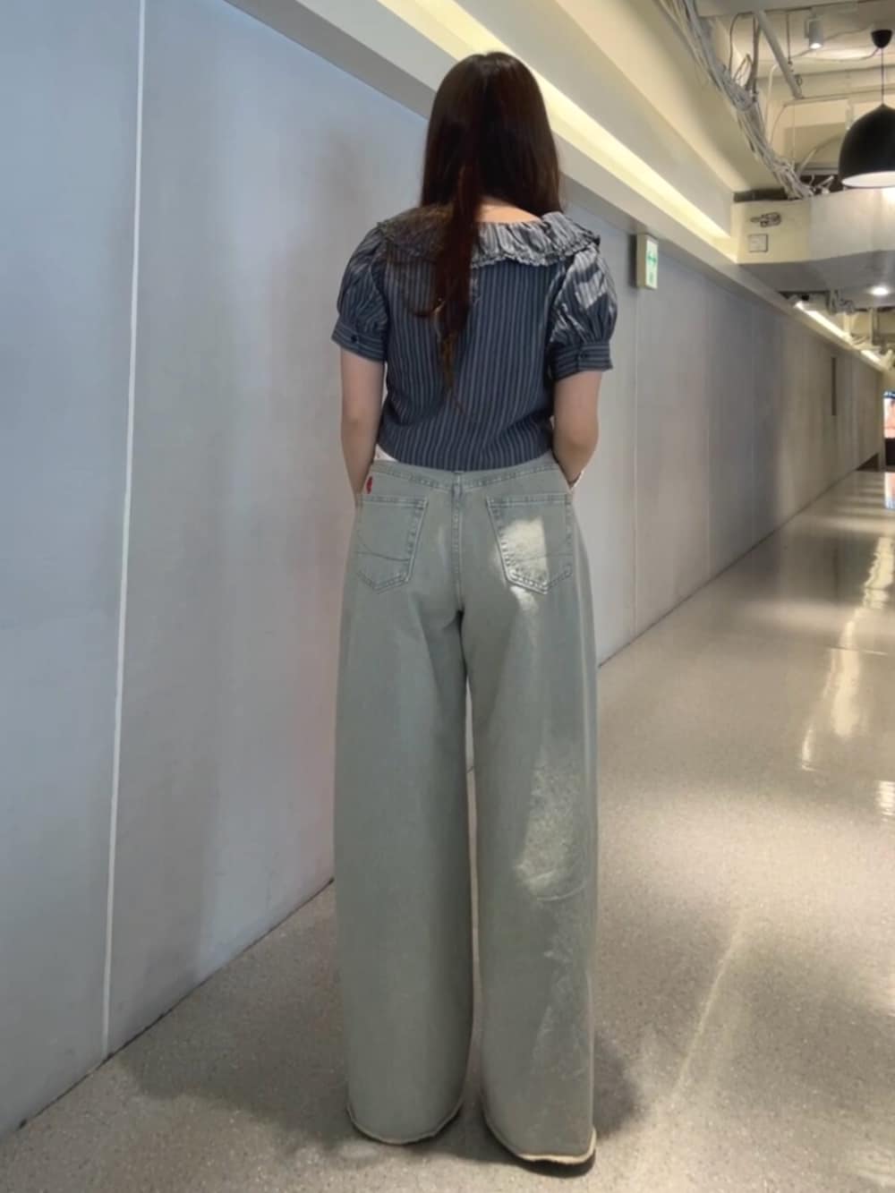 ブラック系のパンプス、ブラック系のシャツ/ブラウス、ブルー系のデニムパンツを着用したレディースの春コーディネートの3枚目の写真
