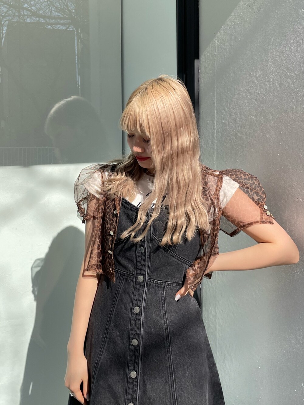 ブラック系のジャンパースカート、ホワイト系のタンクトップ、ブラウン系のシャツ/ブラウスを着用したレディースの春コーディネートの5枚目の写真