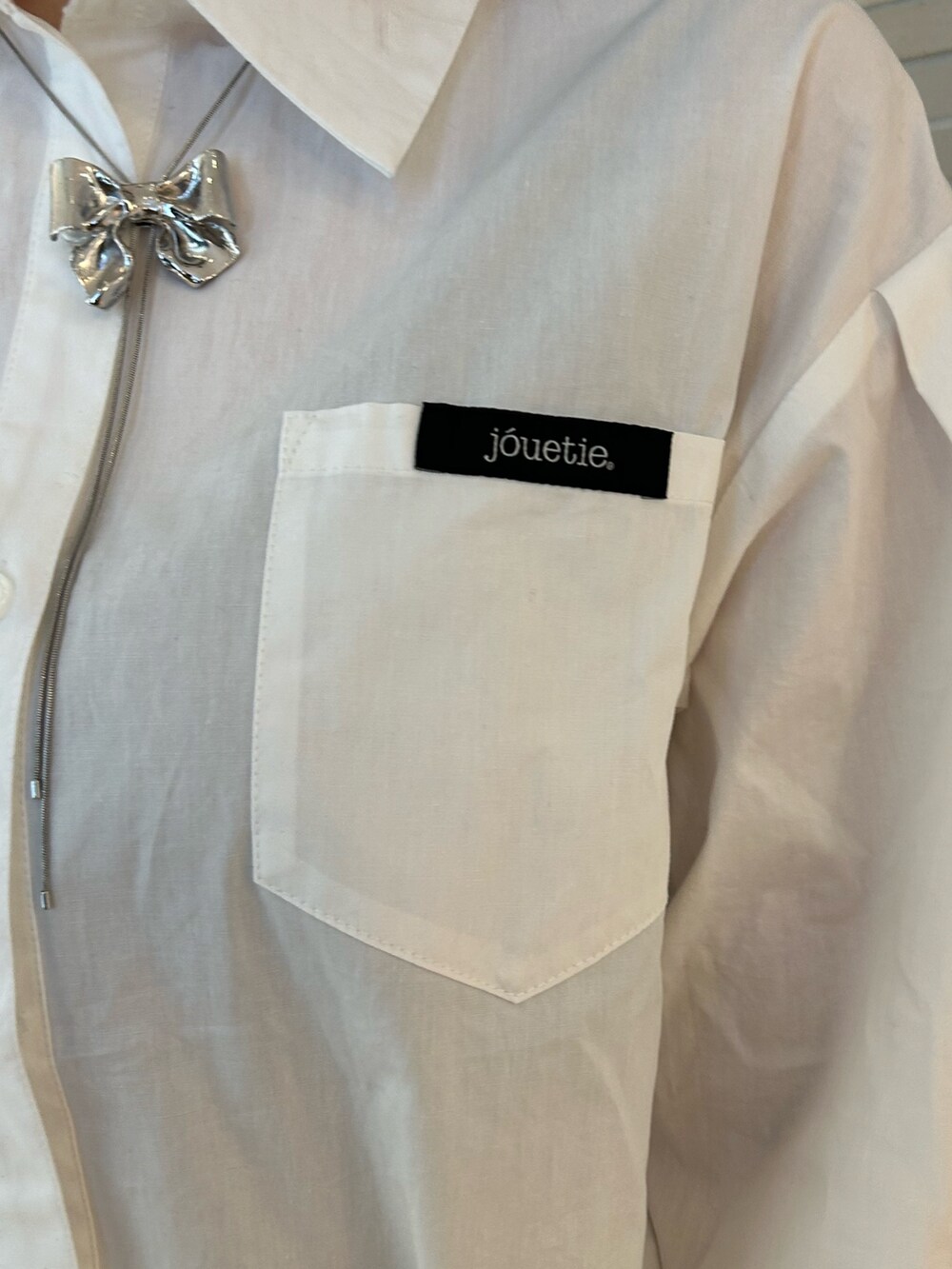 ホワイト系のシャツ/ブラウス、シルバー系のネックレスを着用したレディースの冬コーディネートの5枚目の写真