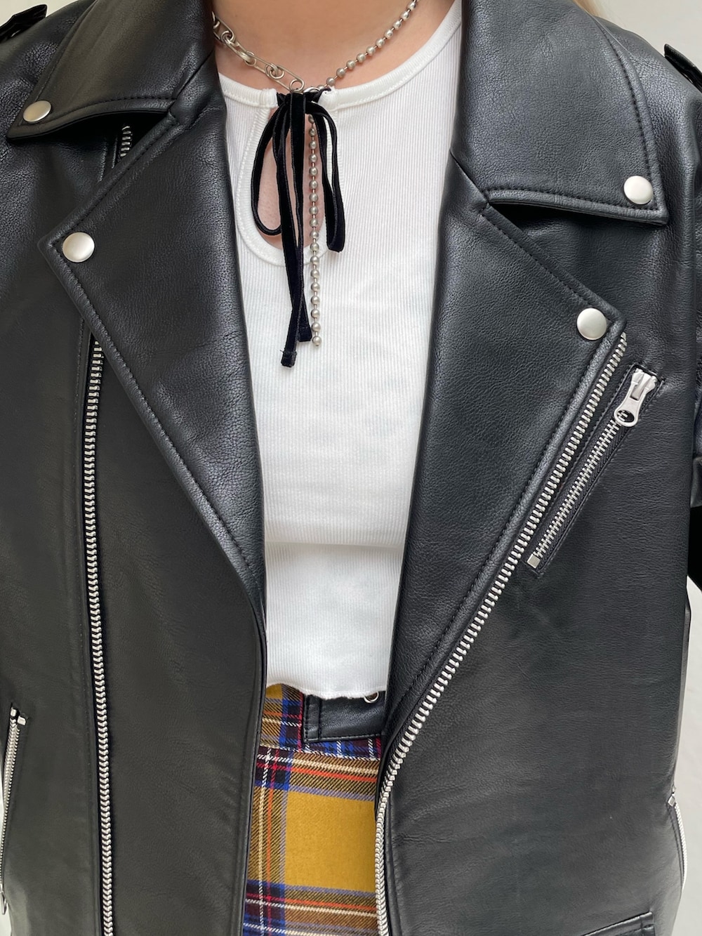 イエロー系のスカート、ブラック系のライダースジャケット、ホワイト系のTシャツ/カットソーを着用したレディースの秋コーディネートの5枚目の写真