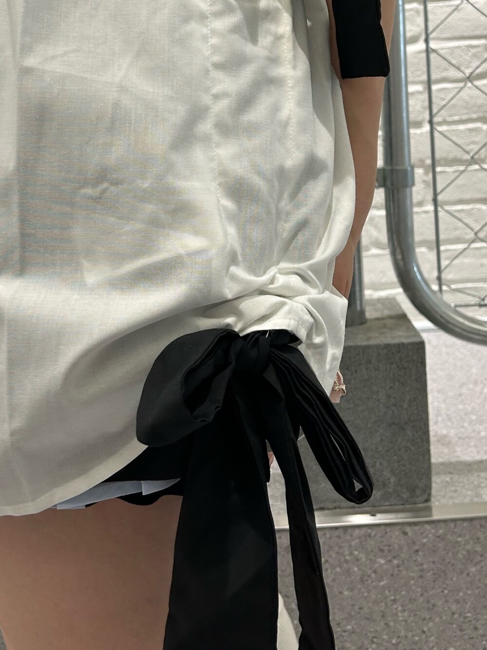 ブラック系のトートバッグ、ホワイト系のシャツ/ブラウス、ブラック系のチョーカーを着用したレディースの夏コーディネートの9枚目の写真