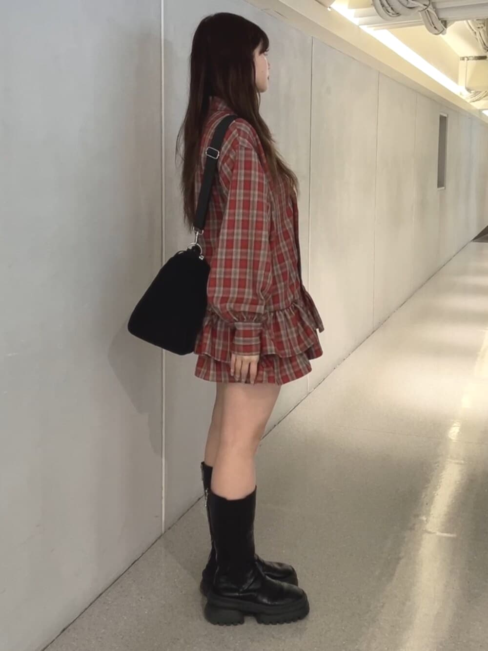 レッド系のワンピース、ブラック系のボストンバッグを着用したレディースの冬コーディネートの2枚目の写真