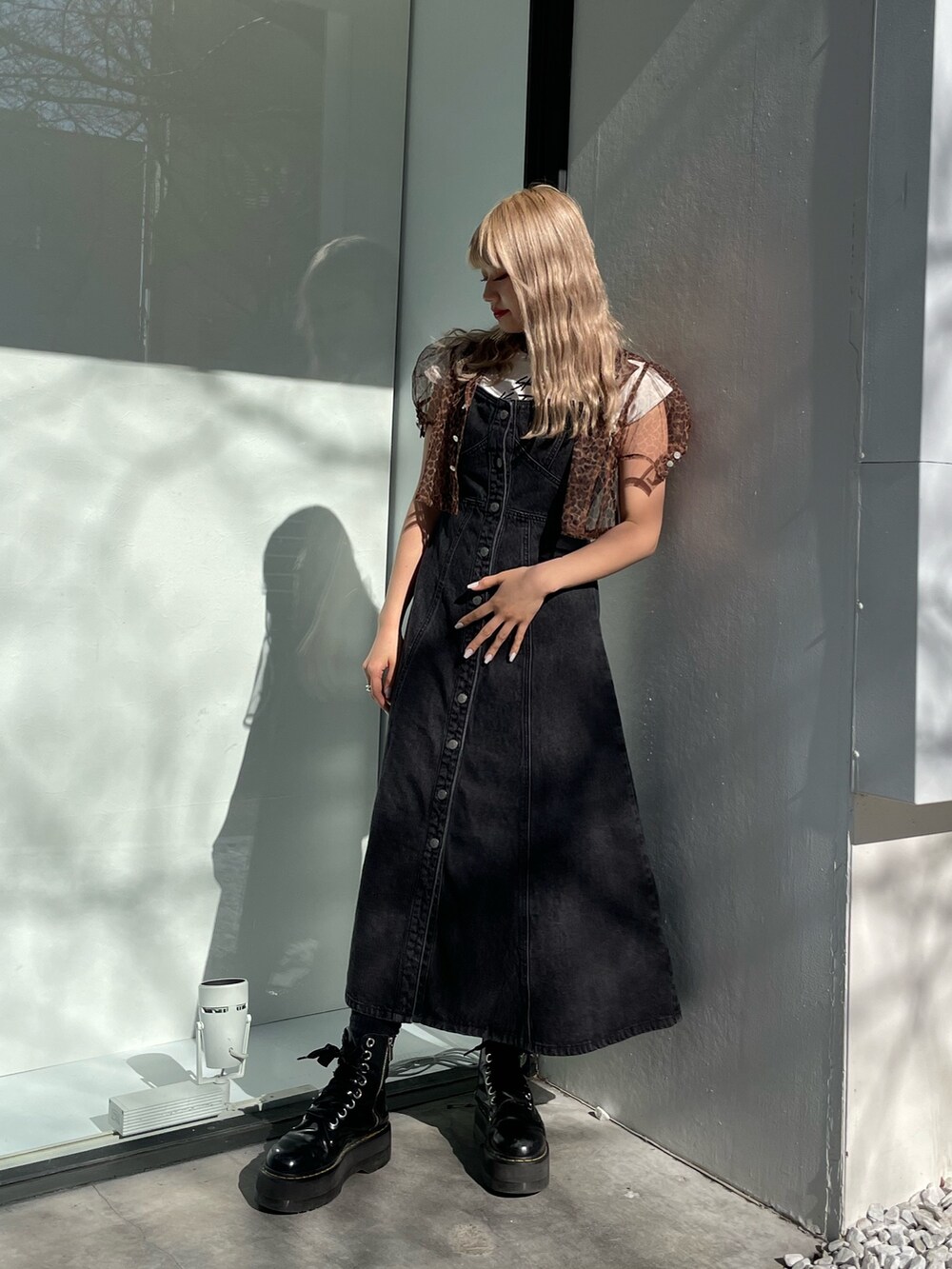 ブラック系のジャンパースカート、ホワイト系のタンクトップ、ブラウン系のシャツ/ブラウスを着用したレディースの春コーディネートの3枚目の写真