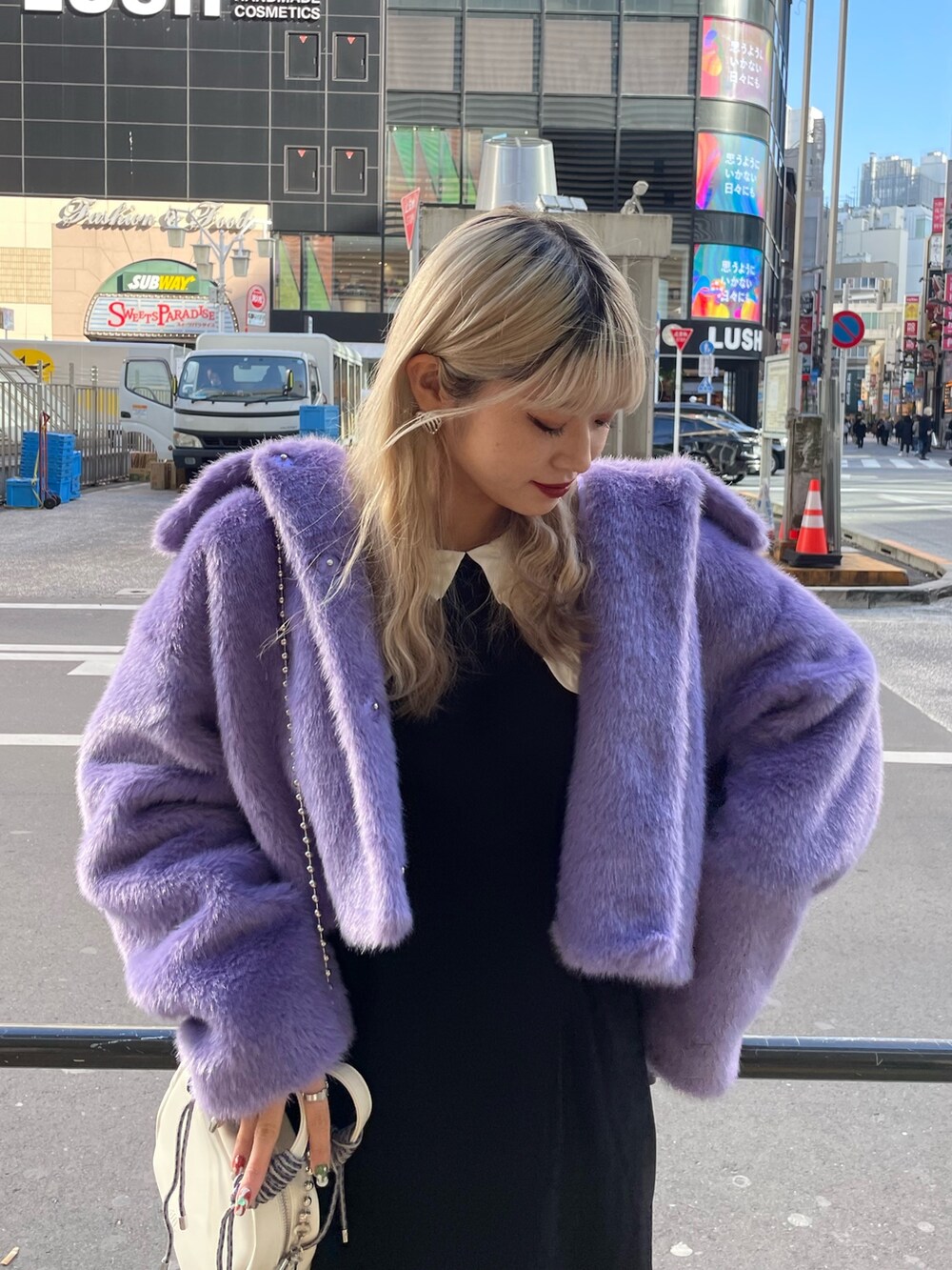 パープル系のその他アウター、ブラック系のワンピース、ブラック系のブーツを着用したレディースの冬コーディネートの3枚目の写真