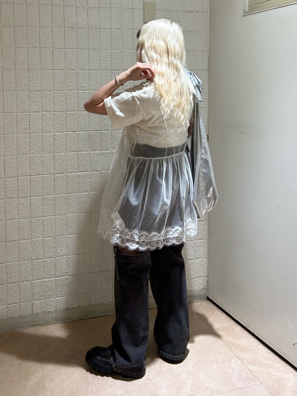 ホワイト系のTシャツ/カットソー、ブラック系のデニムパンツ、シルバー系のトートバッグを着用したレディースの春コーディネートの3枚目の写真