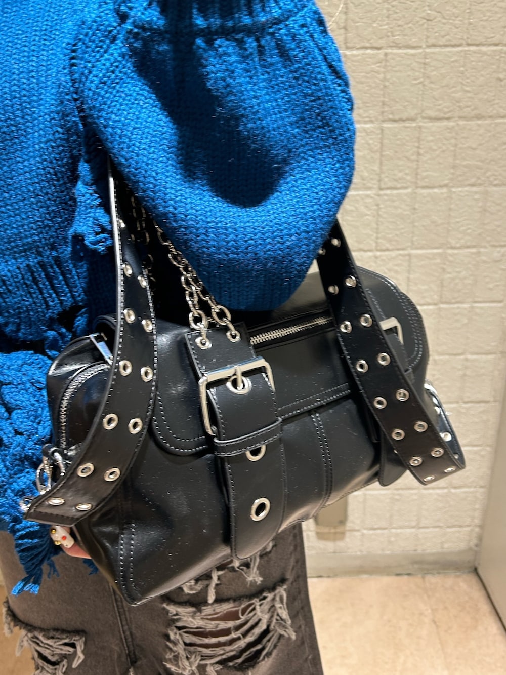 ブラック系のデニムスカート、ブルー系のニット/セーター、ブラック系のブーツを着用したレディースの冬コーディネートの6枚目の写真