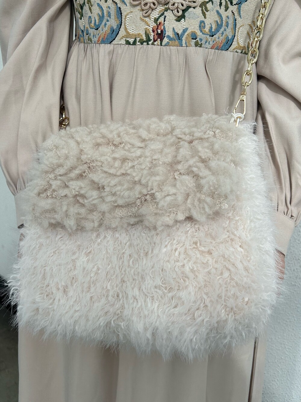 ホワイト系のワンピース、ホワイト系のハンドバッグ、ブラック系のその他シューズを着用したレディースの冬コーディネートの6枚目の写真