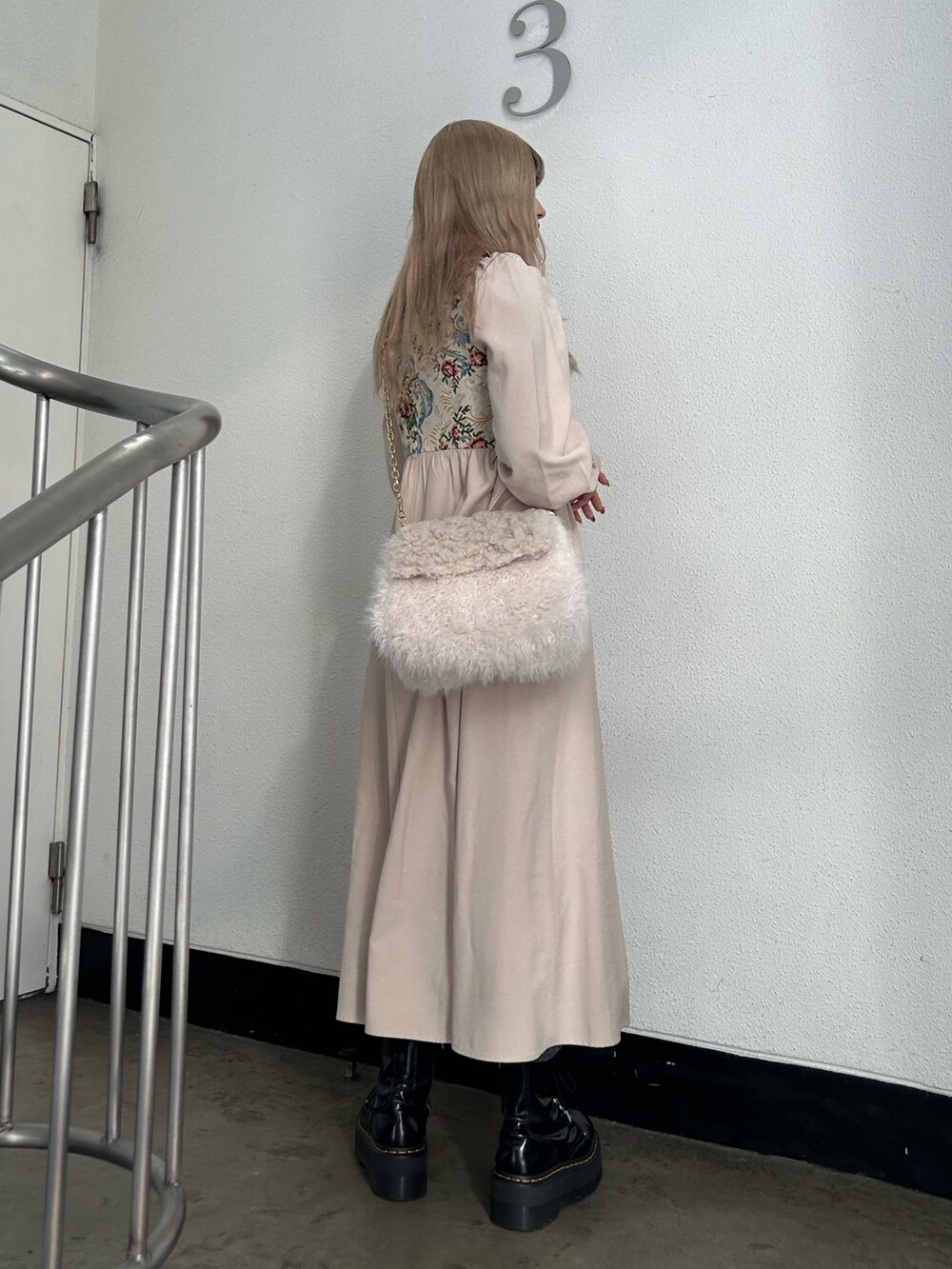 ホワイト系のワンピース、ホワイト系のハンドバッグ、ブラック系のその他シューズを着用したレディースの冬コーディネートの2枚目の写真