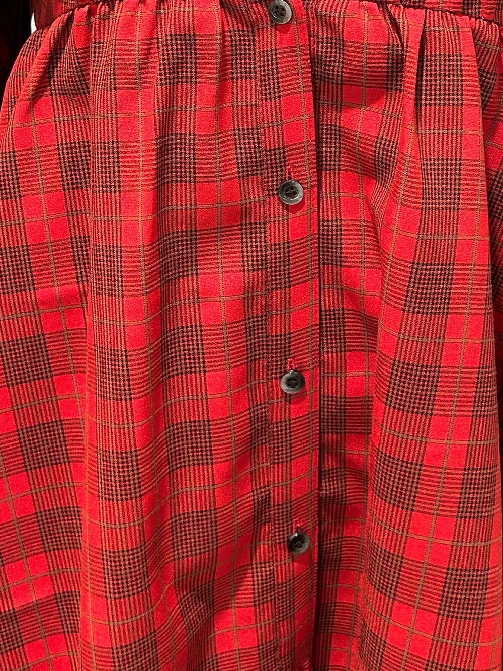 レッド系のワンピース、ブラウン系のブーツ、ブラック系のショルダーバッグを着用したレディースの夏コーディネートの7枚目の写真