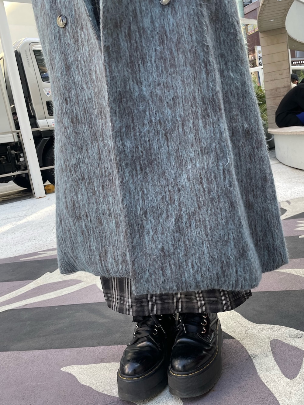 ブルー系のチェスターコート、ブラック系のワンピース、ブラック系のその他シューズを着用したレディースの冬コーディネートの7枚目の写真