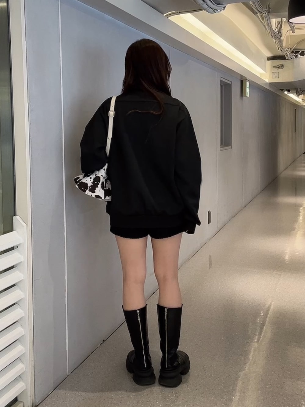 ブラック系のジャージ、ホワイト系のハンドバッグを着用したレディースの冬コーディネートの3枚目の写真