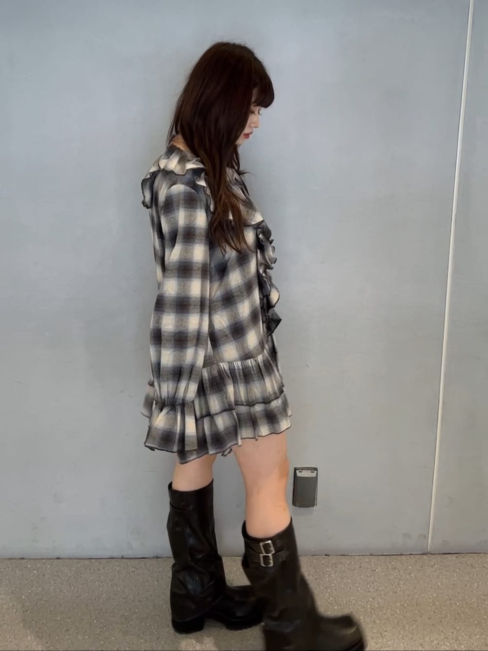 ブラウン系のワンピース、ブラック系のブーツを着用したレディースの秋コーディネートの2枚目の写真