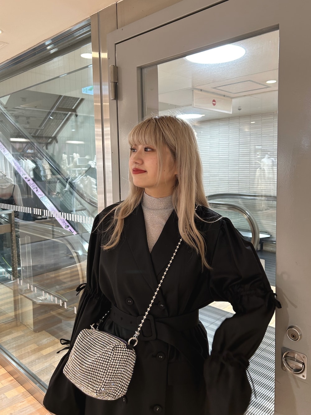 ブラック系のワンピース、シルバー系のTシャツ/カットソー、ホワイト系のショルダーバッグを着用したレディースの秋コーディネートの3枚目の写真