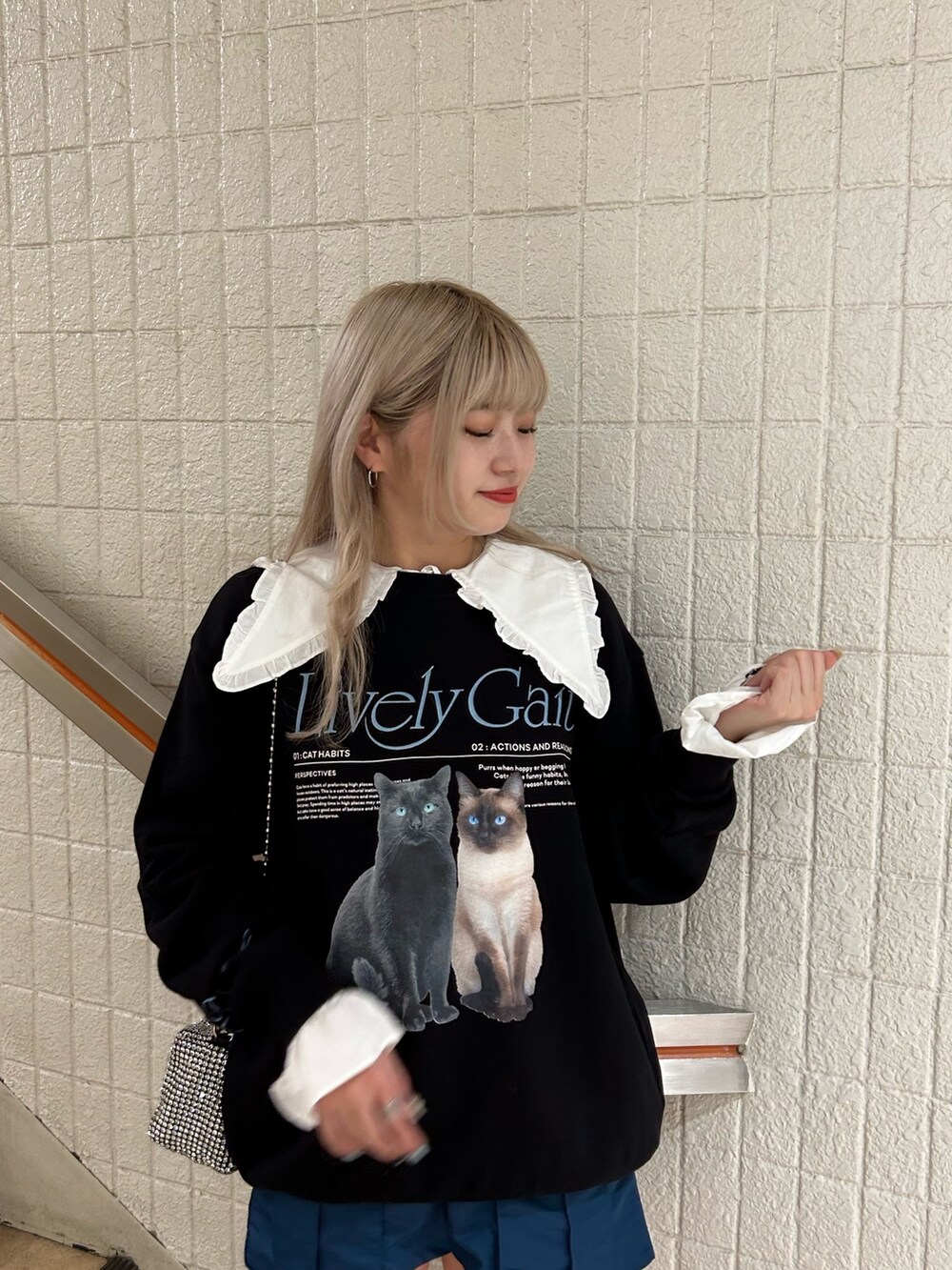 ブラック系のスウェット、ホワイト系のシャツ/ブラウス、ホワイト系のショルダーバッグを着用したレディースの夏コーディネートの3枚目の写真