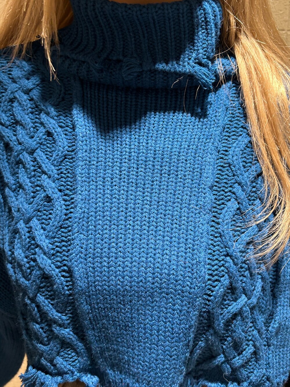 ブラック系のデニムスカート、ブルー系のニット/セーター、ブラック系のブーツを着用したレディースの冬コーディネートの5枚目の写真